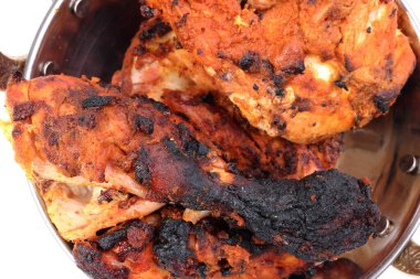 Baharatlı kırmızı tavuk ızgarada tika tandır metal pirinç pirinç bakır kap beyaz arka planda