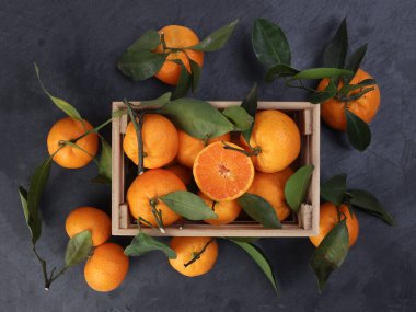 Ahşap sandıkta turuncu turuncu yaprak siyah mermer arka planda üst görünüm