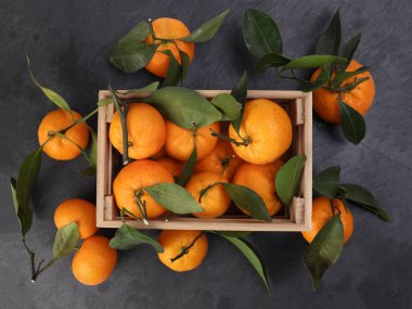 Ahşap sandıkta turuncu turuncu yaprak siyah mermer arka planda üst görünüm