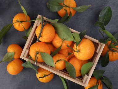 Ahşap sandıkta turuncu turuncu yaprak siyah mermer arka planda üst görünüm