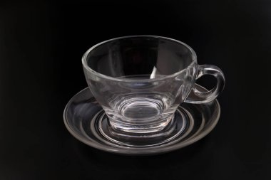 Boş şeffaf cam, siyah arka plandaki çay fincanının içini görüyor.