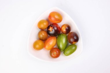 Beyaz arka planda kırmızı turuncu yeşil domates karışımı.