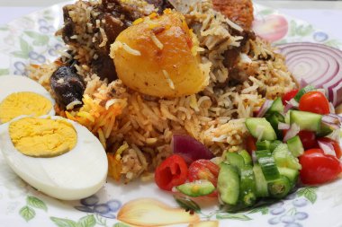 Ev usulü kacchi biryani ve patates pirzolası salatalıklı soğan salatası.