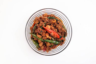 Merdivenler kızarmış Tayland fesleğeni kıyılmış baharatlı kırmızı kırmızı biber, cam kasede beyaz arka planda servis ediliyor.