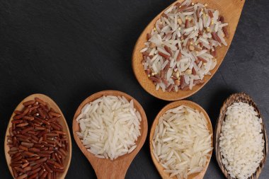 Uzun taneli basmati orta taneli yasemin kısa taneli pilav pilav pilavı kahverengi düşük glisemik indeks gi pilav tahta kaşık içinde siyah arkaplan metin alanı düz görüş alanı