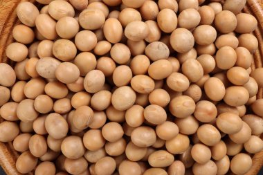 Soyaalılar soya fasulyelerini tahta kasenin üzerine koydular. Arka planda siyah taş. Metin alanı düz yatıyordu.