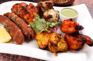Karışık ızgara kebap tavuk sığır eti karides naneli balık limon turşulu soğan kişniş beyaz arka planda beyaz tabak