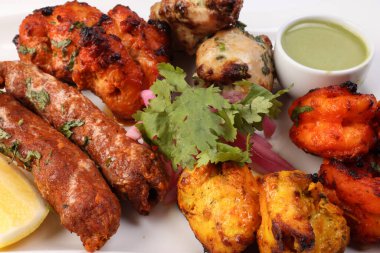 Karışık ızgara kebap tavuk sığır eti karides naneli balık limon turşulu soğan kişniş beyaz arka planda beyaz tabak