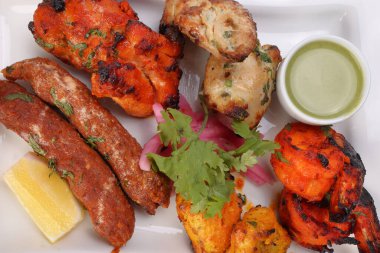 Karışık ızgara kebap tavuk sığır eti karides naneli balık limon turşulu soğan kişniş beyaz arka planda beyaz tabak