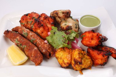 Karışık ızgara kebap tavuk sığır eti karides naneli balık limon turşulu soğan kişniş beyaz arka planda beyaz tabak