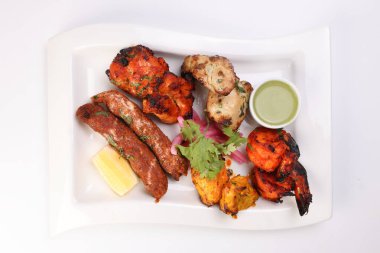 Karışık ızgara kebap tavuk sığır eti karides naneli balık limon turşulu soğan kişniş beyaz arka planda beyaz tabak