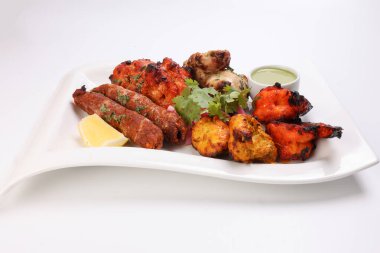 Karışık ızgara kebap tavuk sığır eti karides naneli balık limon turşulu soğan kişniş beyaz arka planda beyaz tabak