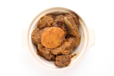 Asya usulü sığır eti, beyaz arka planda seramik kasede patates bulunan kuru köri.