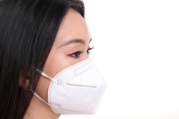 Beautiful young south east Asian woman wearing N95 anti virus bacterial surgical face mask on white background side view