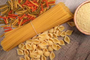 Kuru çiğ spagetti conchiglie deniz kabukları fusilli mantar vida renk makarna kuskus çeşitleri kırsal ahşap arka planda