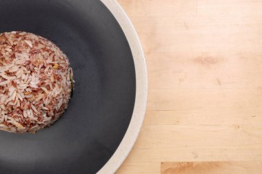 Nasi dagang özel kahverengi pirinç hindistan cevizi sütü ve baharatla pişirilmiş beyaz kaplama, ahşap arka planda.