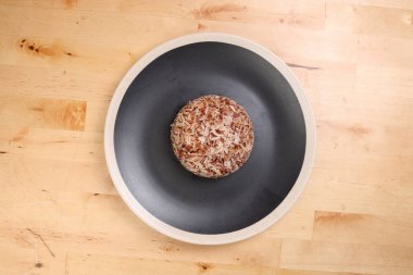 Nasi dagang özel kahverengi pirinç hindistan cevizi sütü ve baharatla pişirilmiş beyaz kaplama, ahşap arka planda.