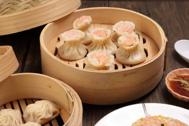 Karidesli shaomai Xiao long bao dim sum hamur köftesi karidesli karides balığı bambu buharlı deniz mahsulü sebze tabak soslu pilav çubukları çorba kaşığıyla kırsal arkaplama