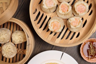 Karidesli shaomai Xiao long bao dim sum hamur köftesi karidesli karides balığı bambu buharlı deniz mahsulü sebze tabak soslu pilav çubukları çorba kaşığıyla kırsal arkaplama