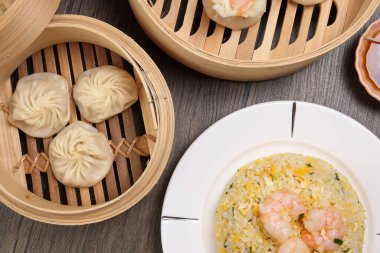 Karidesli shaomai Xiao long bao dim sum hamur köftesi karidesli karides balığı bambu buharlı deniz mahsulü sebze tabak soslu pilav çubukları çorba kaşığıyla kırsal arkaplama