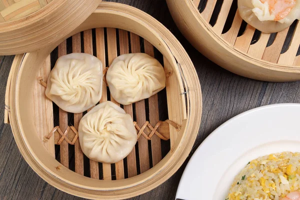 Karidesli shaomai Xiao long bao dim sum hamur köftesi karidesli karides balığı bambu buharlı deniz mahsulü sebze tabak soslu pilav çubukları çorba kaşığıyla kırsal arkaplama