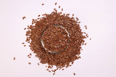 Esnek tohumlu keten tohumu küçük cam kasede beyaz arka plan görünümünde yığının üzerinde