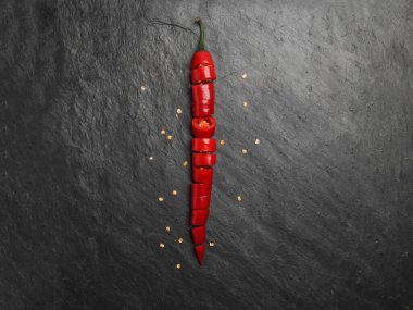 Koyu siyah taştan yüzey zemininde kırmızı kırmızı kırmızı biber.