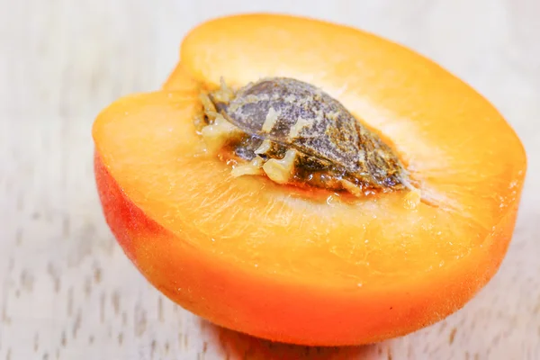 Frische reife saftige Aprikosenhälfte mit Kernen — Stockfoto