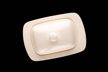 Siyah arkaplanda tereyağı için seramik tereyağı tabağı, yakın plan, üst görünüm.