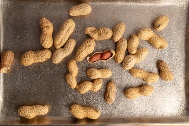 Unshelled raw peanuts, macro, top view.