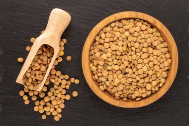 Tahta bir tabakta mercimek, tahta bir taşın üstünde, yakın plan, üst manzara..