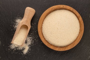 Semolina tahta bir tabakta, tahta bir taşın üzerinde, yakın plan, üst manzara.