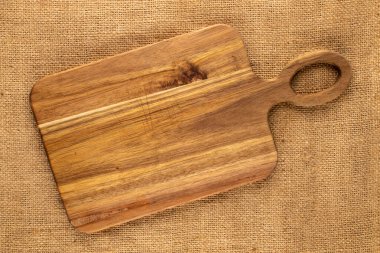Jüt kumaş üzerine ahşap mutfak tahtası, yakın plan, üst manzara..