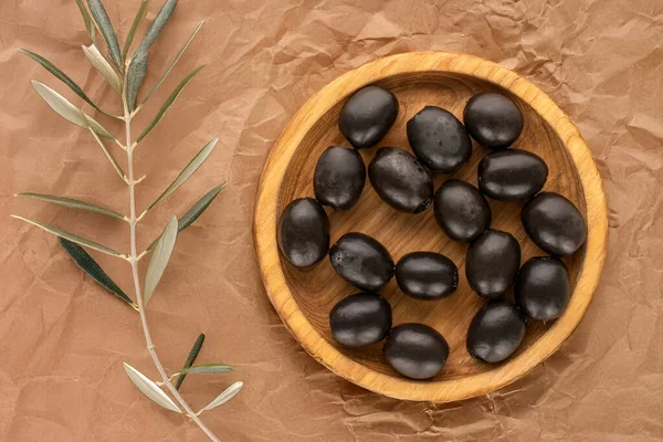 Kraft kağıdına konserve siyah zeytin, üst görünüm.