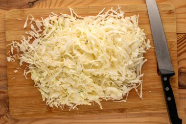 Ahşap mutfak tahtasında doğranmış beyaz lahana, üst manzara, makro..