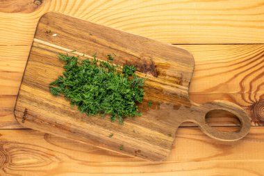 Ahşap mutfak tahtasında doğranmış yeşil maydanoz, üst manzara, makro..