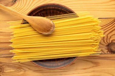 Tahta bir masada çiğ spagetti, üst manzara, yakın çekim..