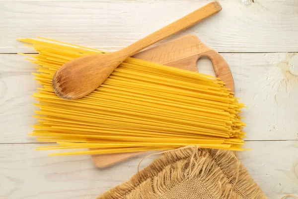 Tahta bir masada çiğ spagetti, üst manzara, yakın çekim..