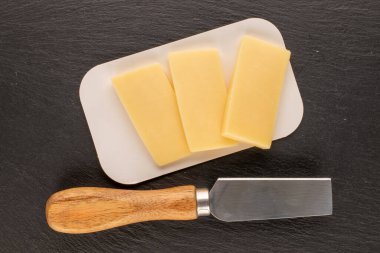 Bir taşın üzerindeki sert peynir kokulu parçalar, üst manzara, makro.