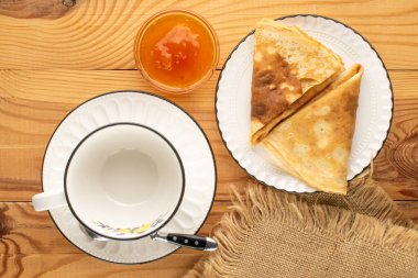 Tahta bir masada kayısı reçelli krep, makro, üst manzara..