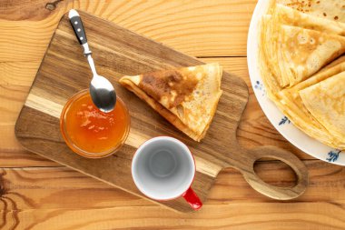 Tahta bir masada kayısı reçelli krep, makro, üst manzara..