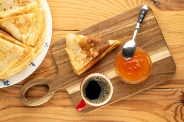 Tahta bir masada kayısı reçelli krep, makro, üst manzara..