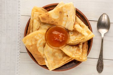 Tahta bir masada kayısı reçelli krep, makro, üst manzara..