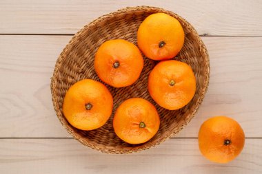 Tahta bir masanın üzerinde sulu olgun mandalinalar, yakın plan, üst manzara..