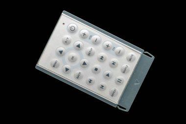 Siyah arkaplanda izole edilmiş bir uzaktan kumanda, yakın plan, üst görünüm.