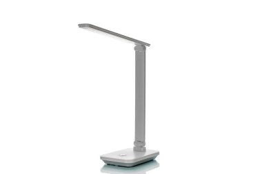 Beyaz arkaplanda bataryaları olan masa LED lambası, yakın plan.