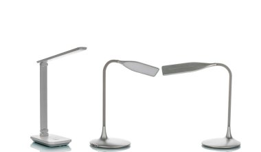 Beyaz arkaplanda bataryaları olan masa LED lambası, yakın plan.