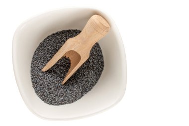 Beyaz arka planda mutfak gereçleri olan kuru haşhaş tohumları, yakın plan, üst manzara.