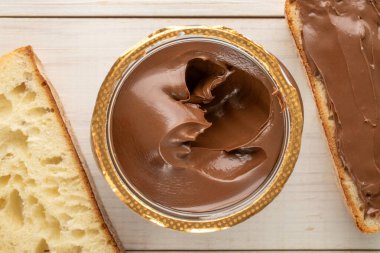 Cam bir kavanozda çikolata ezmesi, ahşap bir masa, üst manzara, makro.