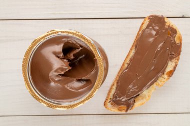 Cam bir kavanozda çikolata ezmesi, ahşap bir masa, üst manzara, makro.